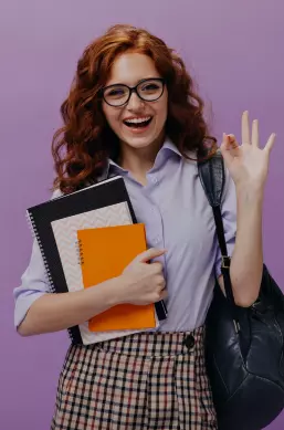red-haired-lady-eyeglasses-holds-books-shows-ok-sign (1) 1 (convert.io)
